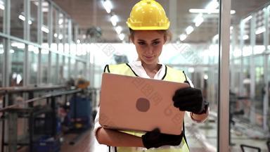 肖像手册女人工人电脑笔记本移动PC穿西装绿色反光安全衣服头盔高科技清洁工厂概念聪明的行业工人操作